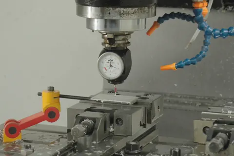 Relógio comparador montado no fuso de um centro de maquinação CNC, sobre uma peça