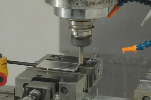 Fresa de um centro de maquinação CNC sobre uma peça presa numa prensa